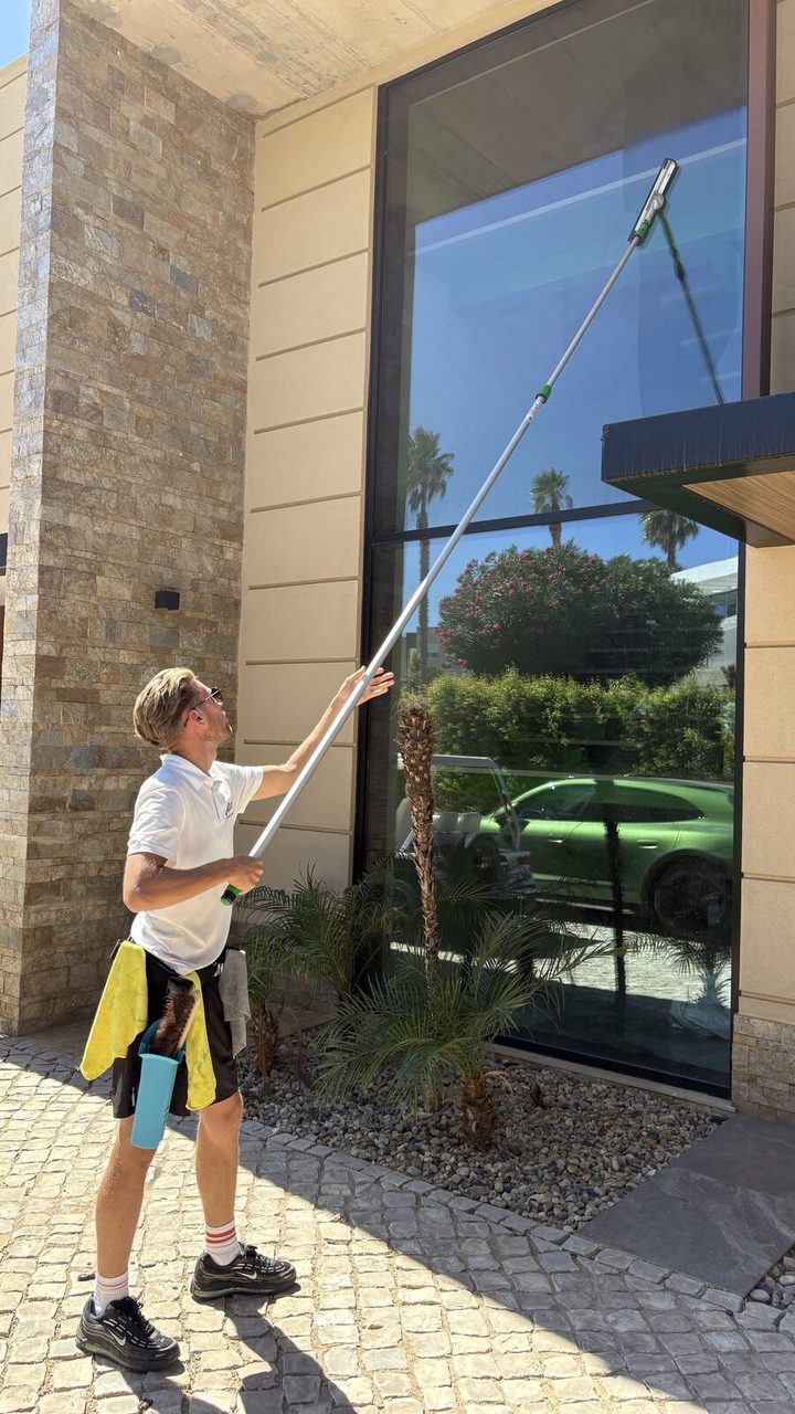 Cleaning a full-height picture window at a villa in Vale Formoso, Almancil