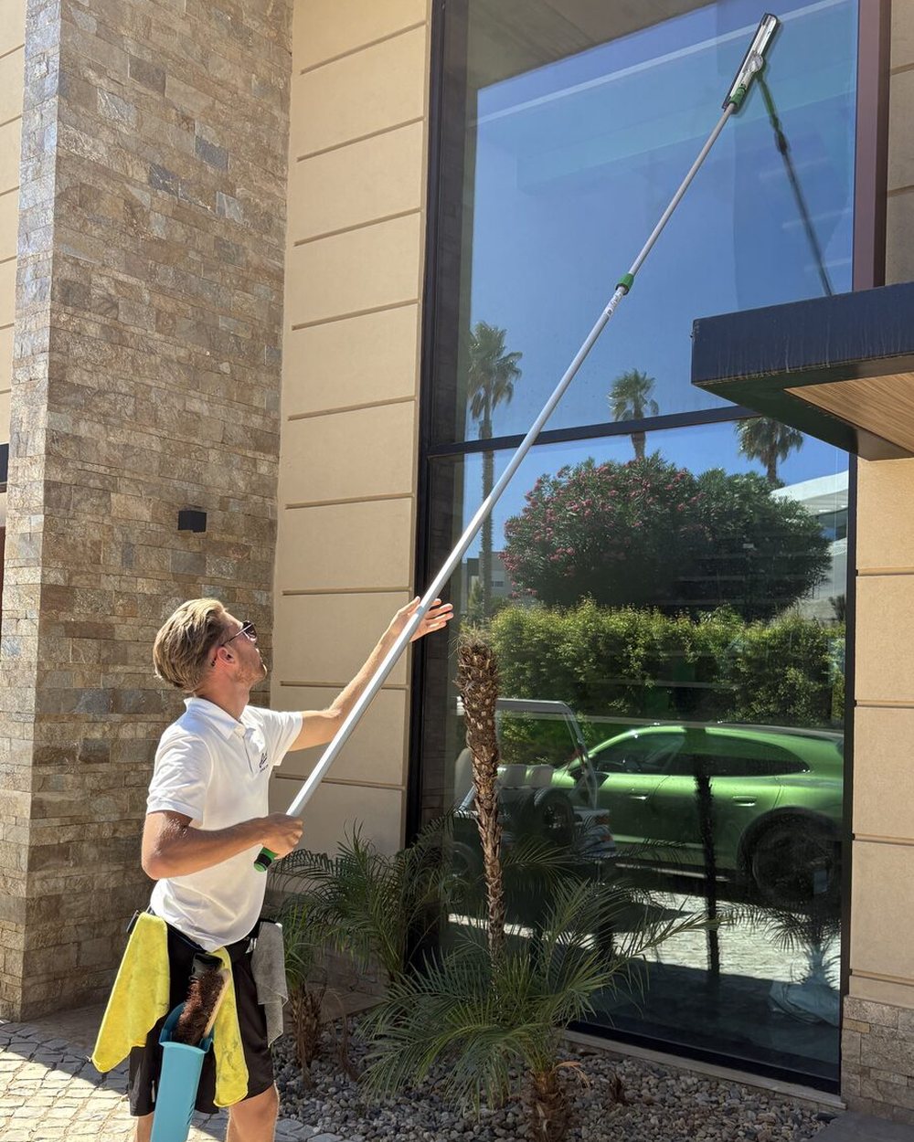 Cleaning a full-height picture window at a villa in Vale Formoso, Almancil