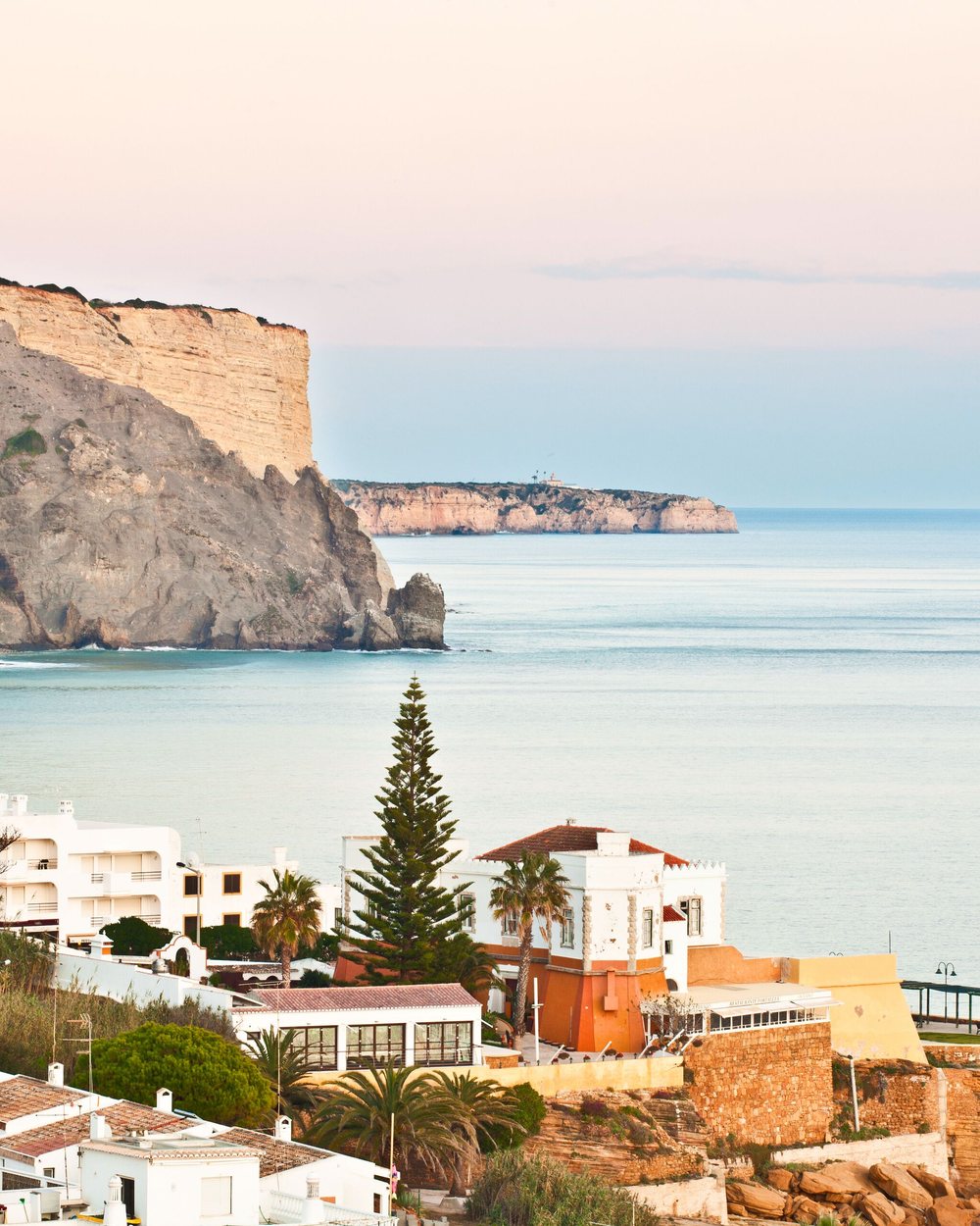 Whitewashed village of Luz below the Rocha Negra cliff, Algarve