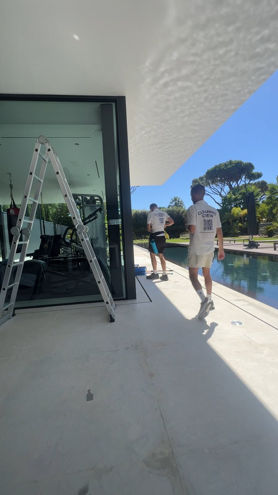 Ben and Alex setting up at the glass doors beside the pool at a Vale do Lobo villa