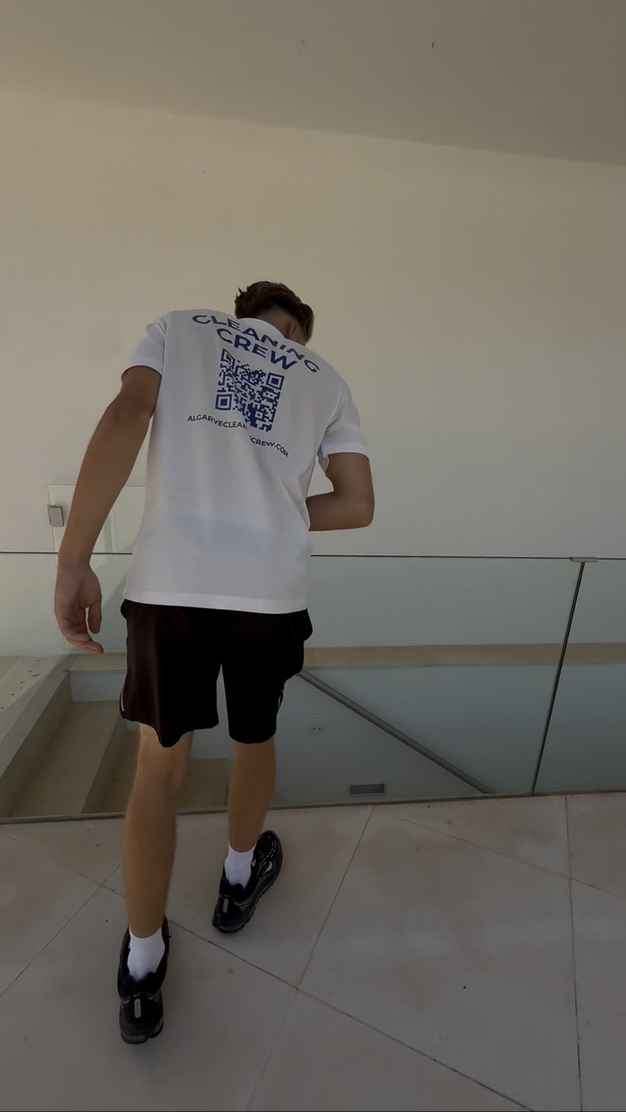Cleaning an interior glass balustrade on the landing of a villa in Pinhal Velho, Vilamoura