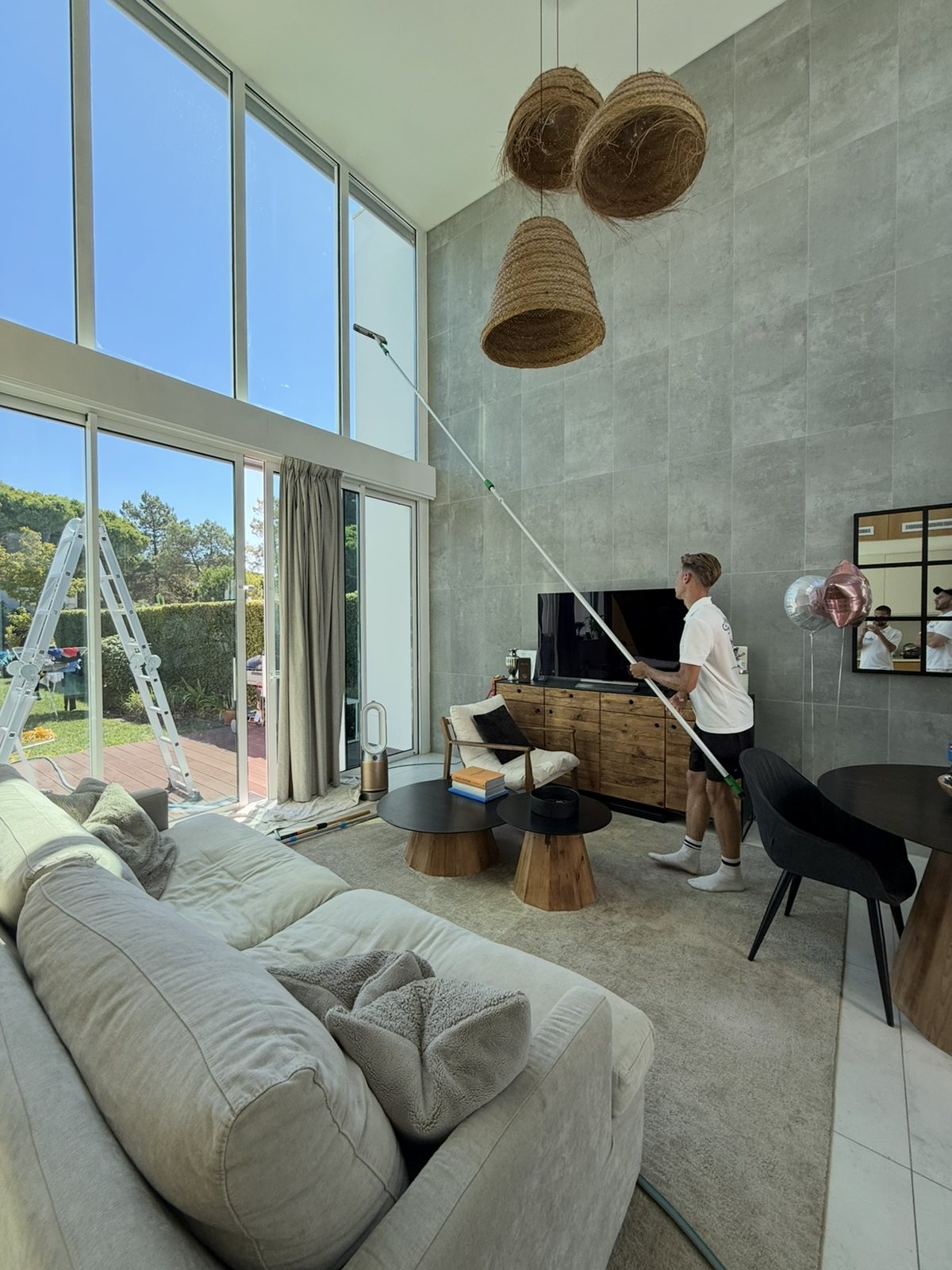 Working the inside of the high glass in the living room of a Lagos villa