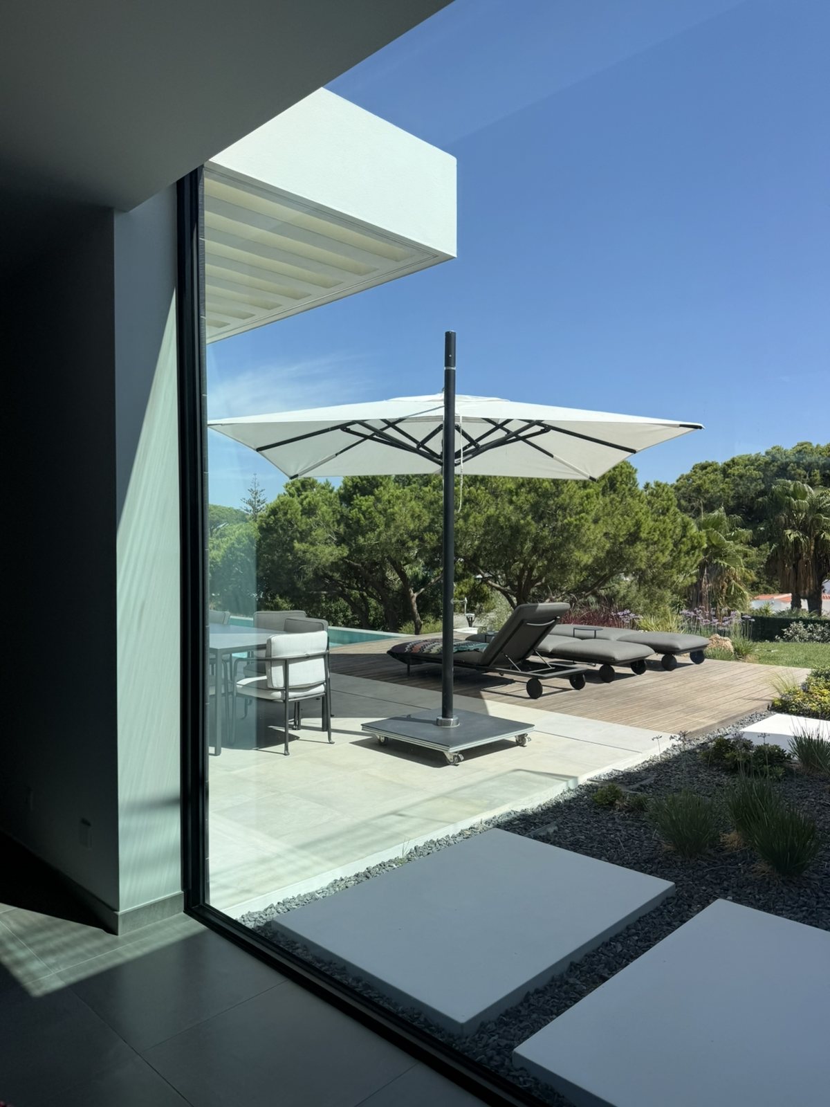 View through clean sliding glass to the terrace of a villa in Lagoa