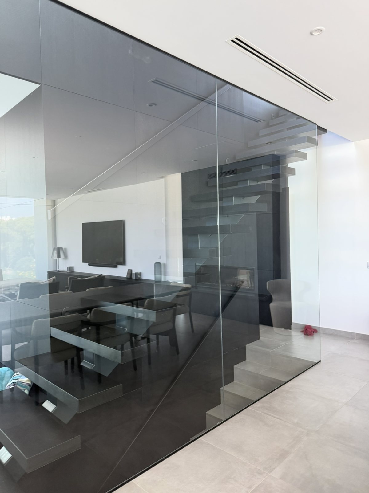 Glass stair enclosure inside a villa in Lagoa