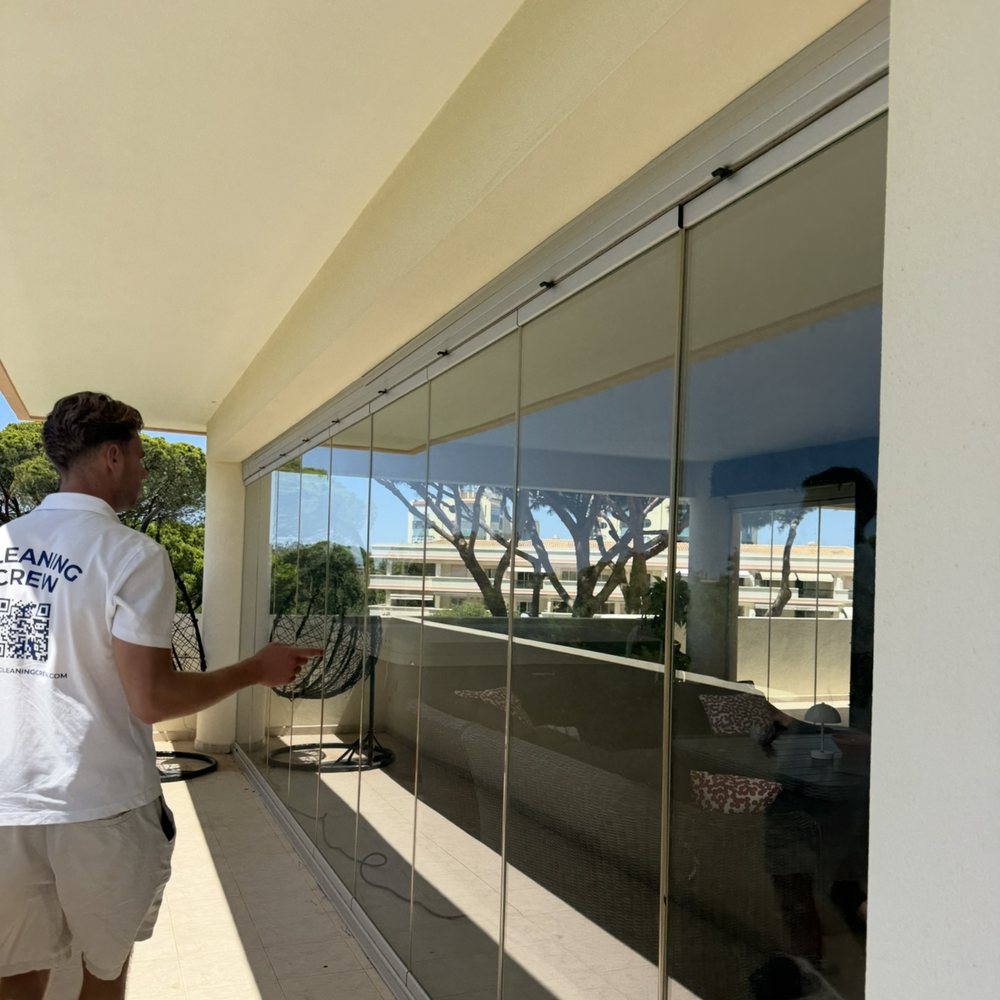 Cleaning the frameless glass enclosure around an apartment terrace in Lagos