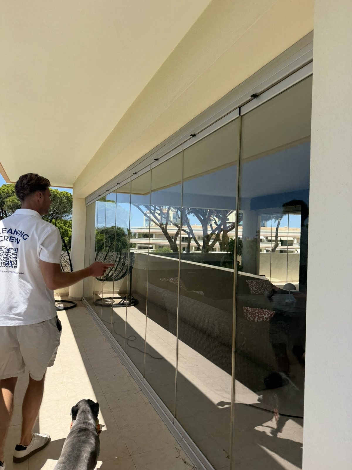 Cleaning the frameless glass enclosure around an apartment terrace in Lagos