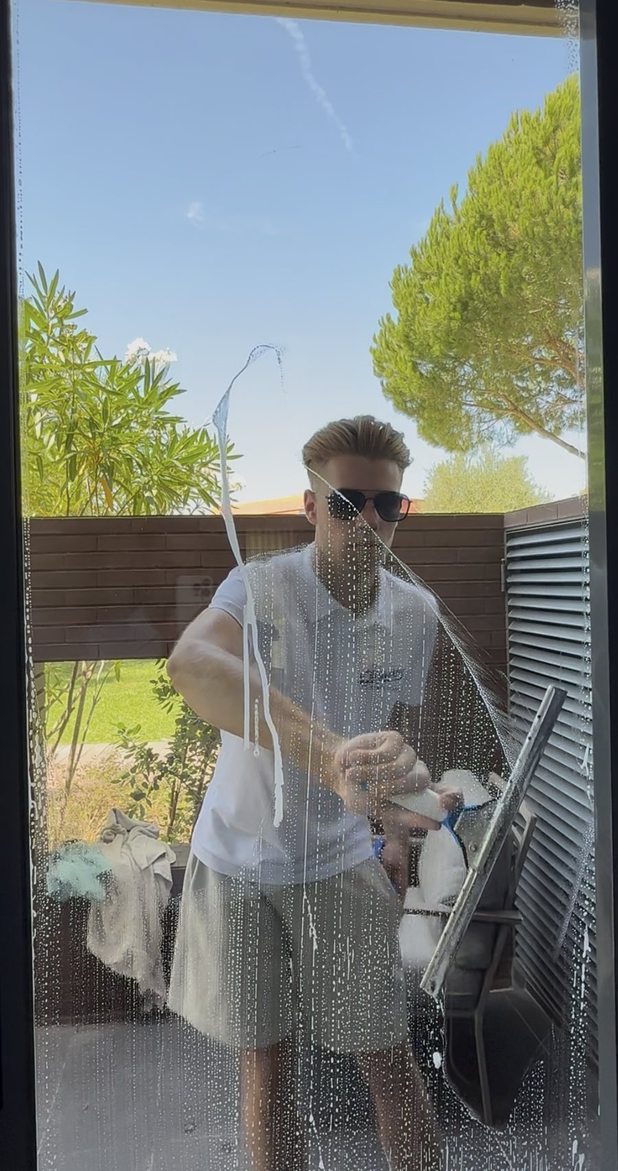 Window cleaning an apartment in Vilamoura with the garden and pines behind