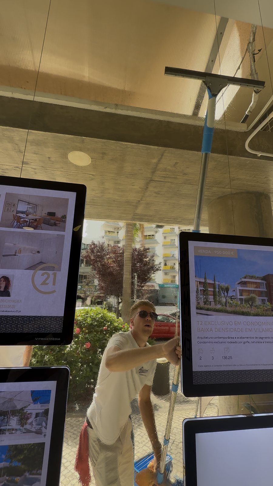 Behind the displays Cleaning the glass behind the Century 21 Oceanic property display screens, seen from inside the office