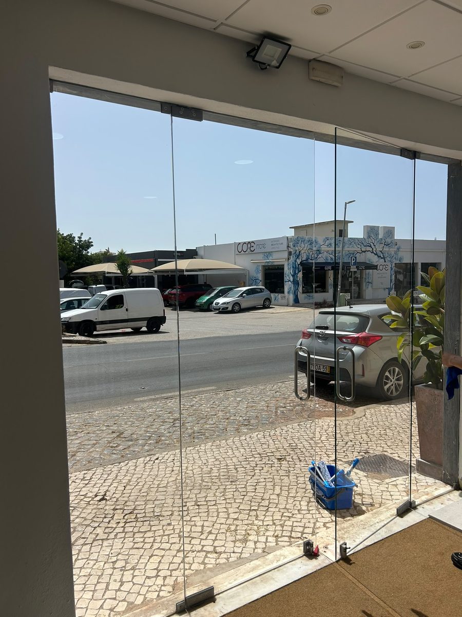 The full-height frameless glass frontage of a showroom in Almancil, cleaned by Algarve Cleaning Crew