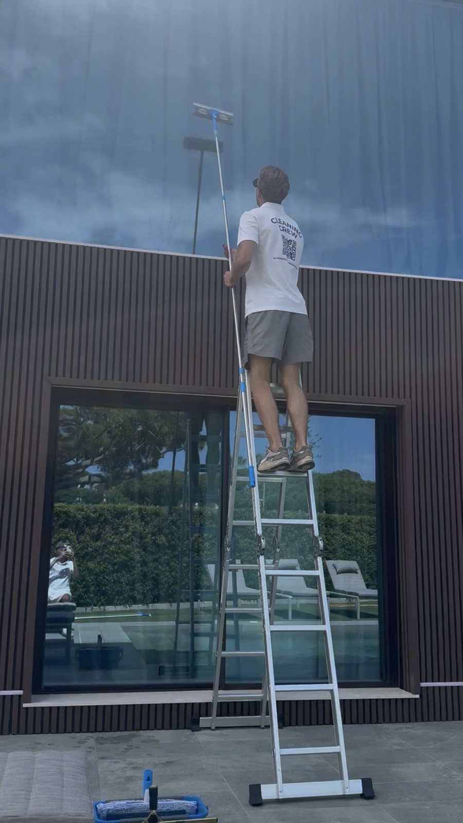 Cleaning high-level villa glass from a ladder in Vale do Lobo