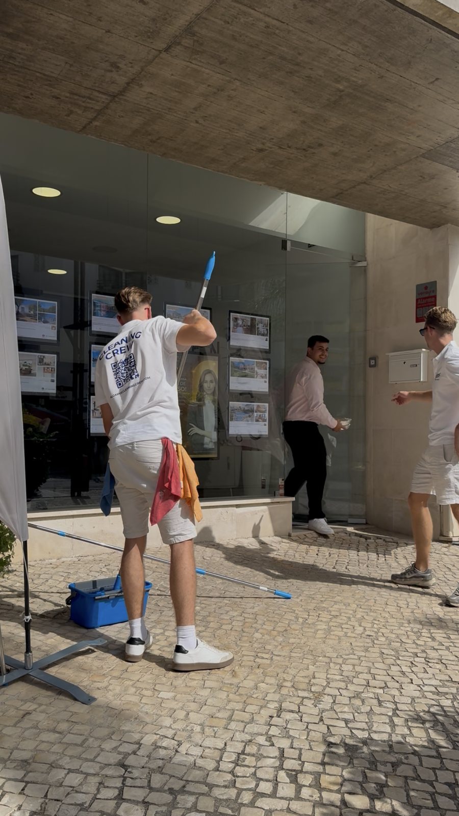 High-level glazing Cleaning high-level shopfront glazing from the ground with an extension pole, Vilamoura Marina