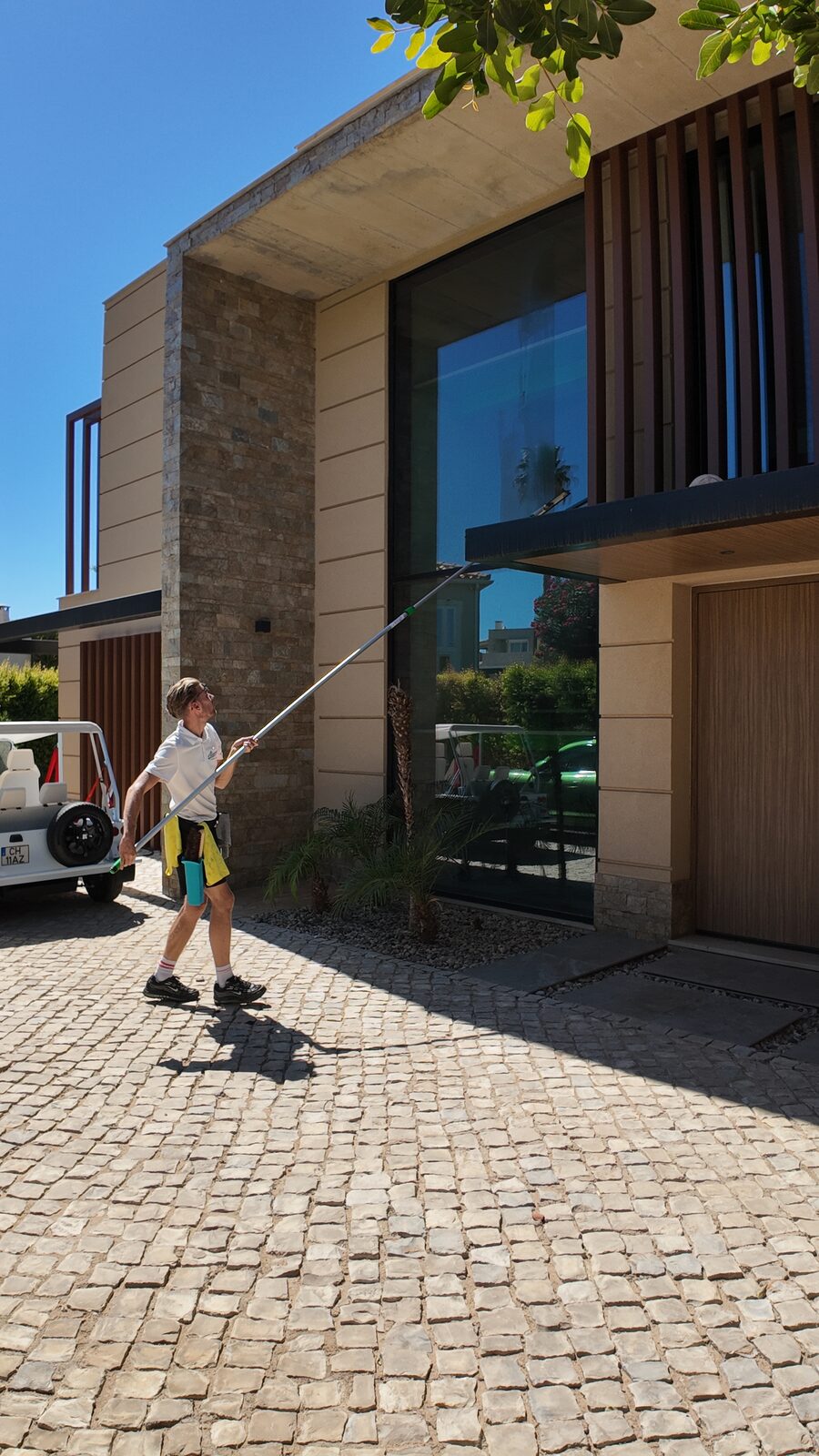 Working the top of a double-height villa window from the drive in Vale Formoso