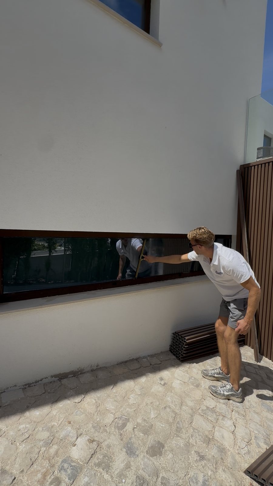 Cleaning a long ribbon window on a villa in Vale do Lobo