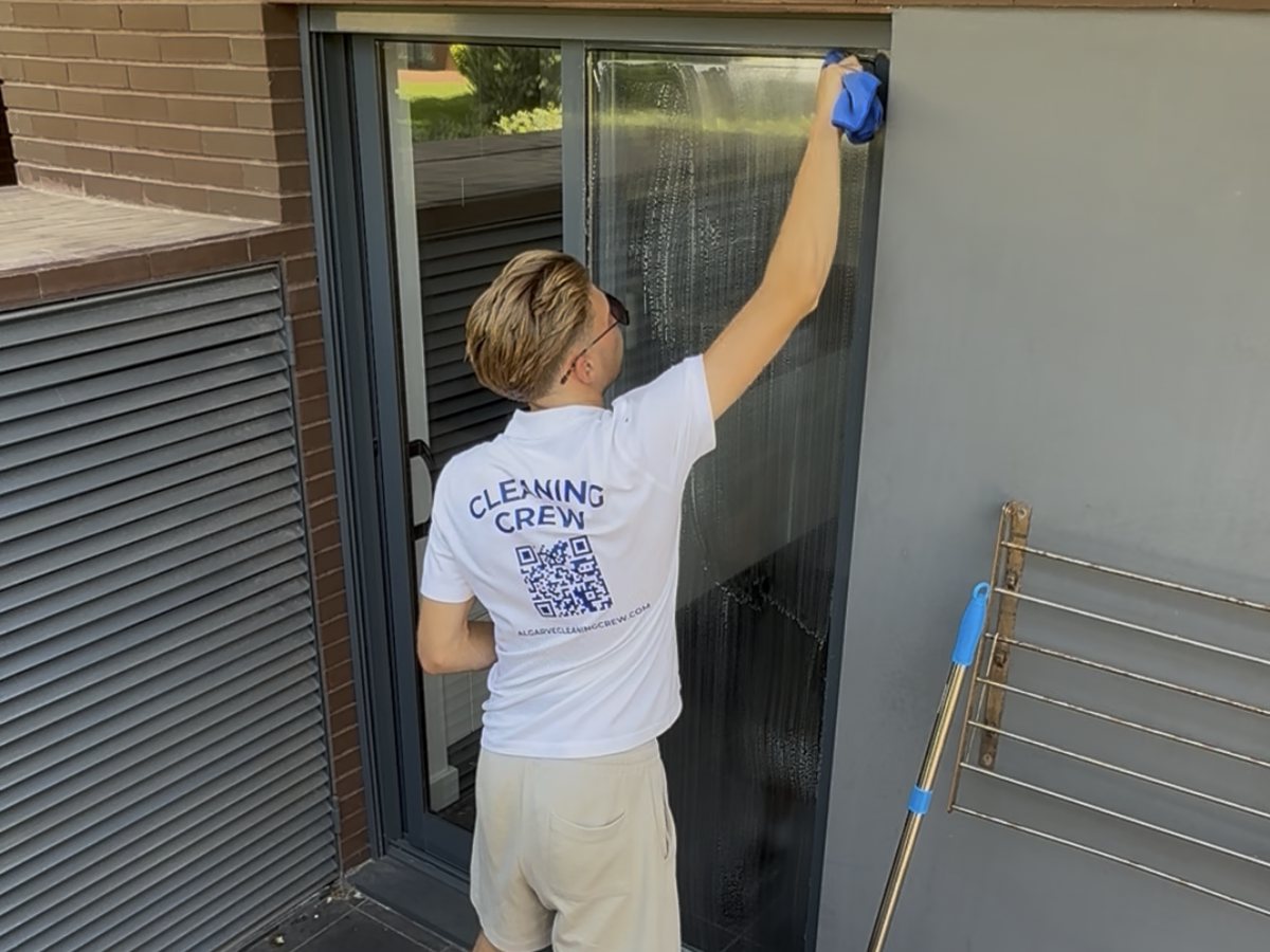 Window cleaning the sliding patio doors of an apartment in Vilamoura, Algarve