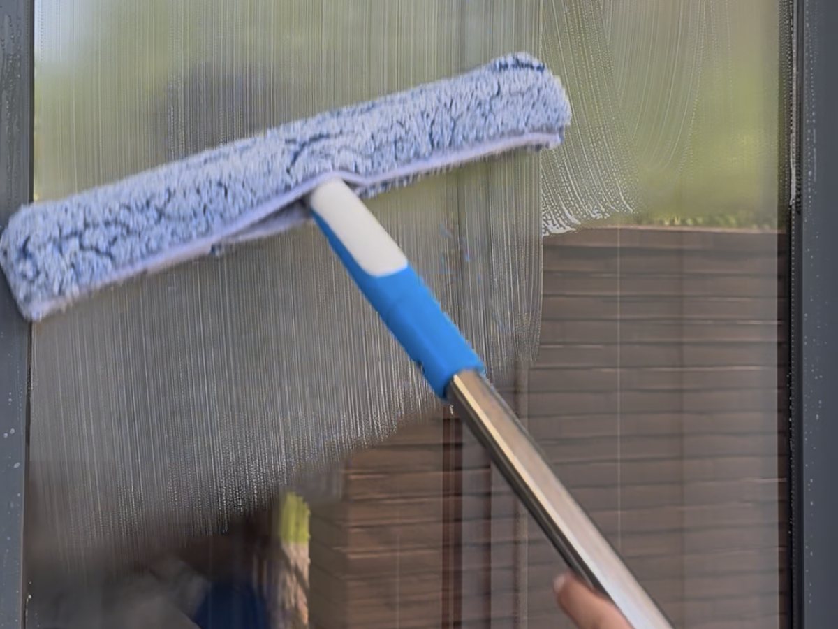 Window cleaning applicator washing down glass in the Algarve